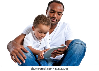 Baby playing with tablet PC under his father's control / photos of Hispanic man and mixed race boy over white background
