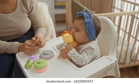 Baby playing with toy in high chair while woman sits nearby, capturing a tender home moment in a cozy room with subtle family interaction and child development focus.