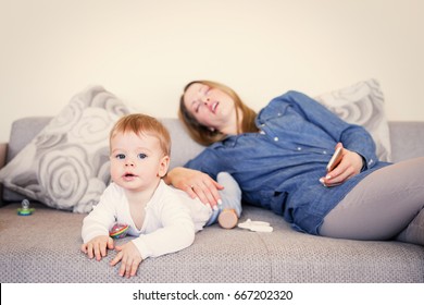 Baby Playing While Mother Is Sleeping