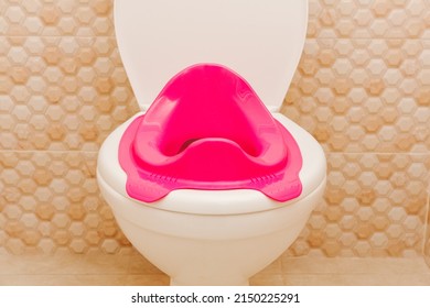 Baby Potty And Baby Pink Toilet Seat. Hygiene. Children's Toilet. Children's Pad, Cover. The Child Goes To An Adult Toilet.