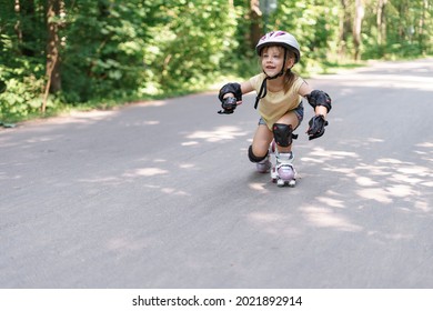 Baby In Protective Sportswear. Little Girl Learning To Roller Skate