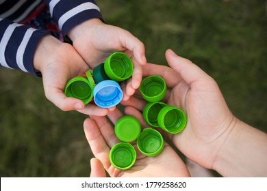 baby puts plastic lids in mother's hands. parent and his child collect cover. recyclable. collecting bottle caps. - Shutterstock ID 1779258620
