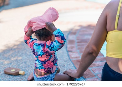 Baby Putting On Her Hat At The Pool During A Hot Summer Day