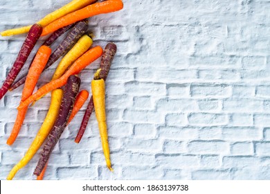 Baby Rainbow Carrots On A White Background With Copy Space - Overhead View