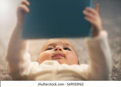 Baby Reading A Book On Back