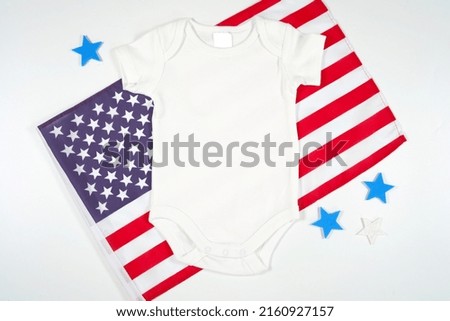 Baby Romper Onesie Bodysuit Jumpsuit Product Mockup. Patriotic Fourth of July, Independence Day theme craft product mockup styled with USA Stars and Stripes flag against a white background.