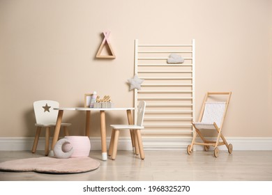Baby room interior with stylish table, chairs and toys