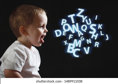 Baby Says, The Concept Of Problems With Dyslexia And Dysgraphia. A Child Learns To Speak, A Boy On A Black Background, A Cloud Of Chaotic Letters On The Right