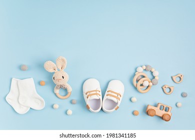 Baby shoes, bib and teether on pastel background. Organic newborn accessories - Shutterstock ID 1981341185