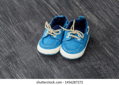 Baby shoes on a wooden background with space for text. Top view