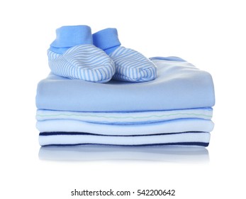 Baby Shoes And Pile Of Clothes On White Background