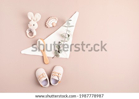 Baby shoes, rattle and teether on neutral background. Organic newborn gifts