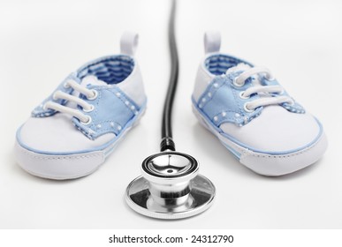 Baby Shoes With Stethascope Against A White Background.