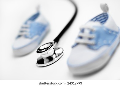 Baby Shoes With Stethascope Against A White Background.