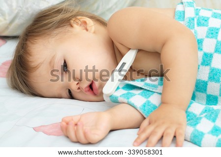 Baby sick with measuring electric thermometer. Child fever ill. Kid catch cold with temperature. Sick child in bed with fever measuring temperature with medical thermometer.
