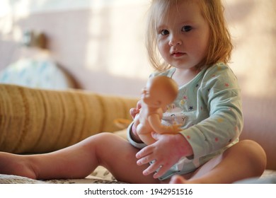 Baby Sits With A Bobblehead Doll, Whose Head Is Turned