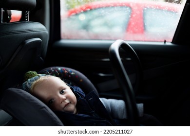 Baby Sitting In A Car In A Carrier, Photo With Depth Of Field. Child Safety Concept