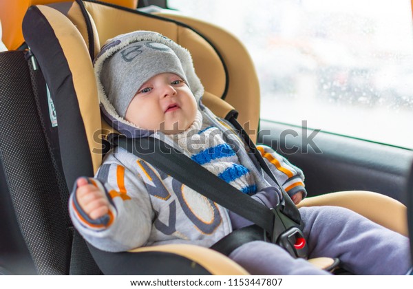 baby sitting\
in the car, fastened in a safe\
chair