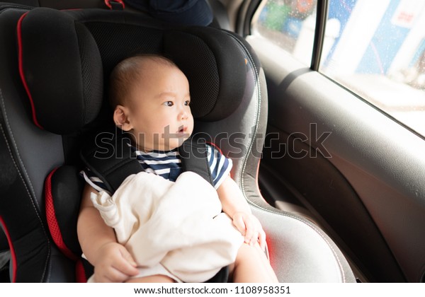 Baby sitting in a car in\
safety chair