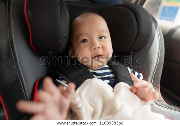 Baby sitting in a car in\
safety chair