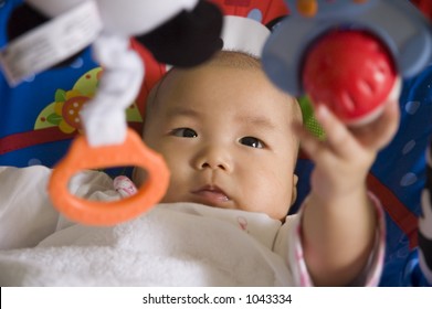 Baby Sitting On A Rocker Learning To Hold A Ball