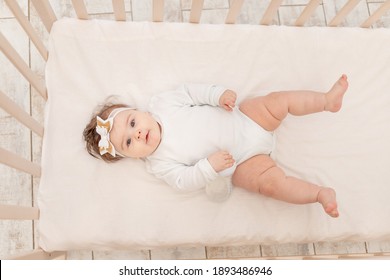 Baby Six Months In Bed With A Bottle Of Water In A White Bodysuit