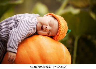 baby sleeping on big pumpkin
