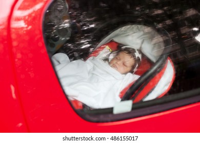 A Baby Sleeping In A Special Car Seat.