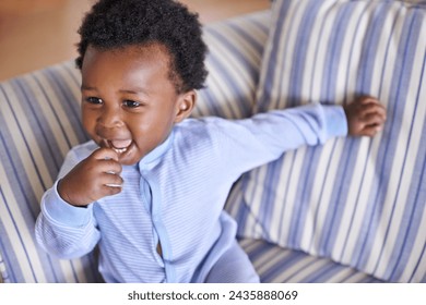 Baby, smile or sofa as play, fun or game for leisure and playing, growth as relax, learn or humor. Excited, black boy child or laugh as curious confidence for motor skill coordination or development - Powered by Shutterstock