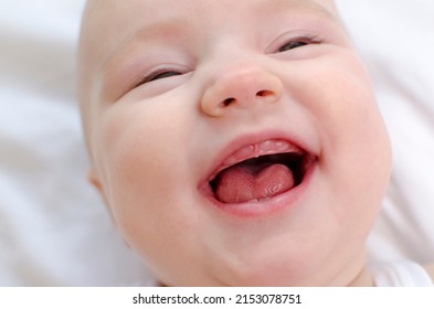 Baby Smiling With A Toothless Mouth Close-up. Infant Laughing. Children Healthcare