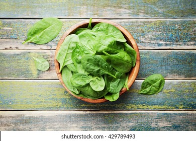 Baby Spinach Leaves In Wooden Bowl On Old Rustic Table, Organic Food, Top View.