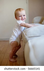 Baby Standing Up Next To Furniture