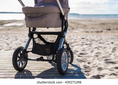 Baby stroller on beach at sunny day