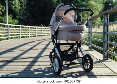 Baby stroller on running path in park at sunny day