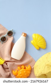 Baby Sunscreen Cream Bottle, Sunglasses, Sand Molds Toys On Blue Background. Flat Lay, Top View