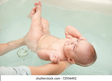 Baby Swimming On Mother's Hands In Bath