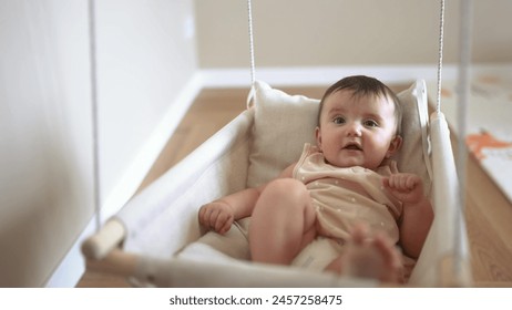 baby is swinging on swing. baby blonde play at home sits on a rope swing. happy family kid dream kindergarten concept. pov view of baby playing in baby lifestyle swing indoors - Powered by Shutterstock