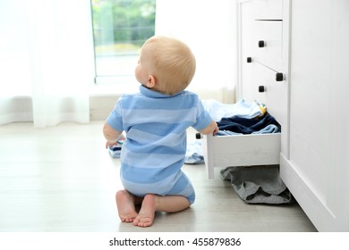 Baby Throwing Up Clothes From Wooden Chest