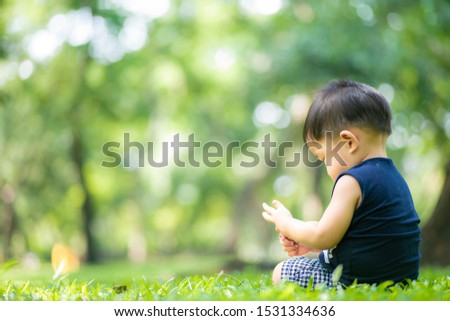 Baby toddler boy playing with toy and nuture in city public park, 1 year boy recreation