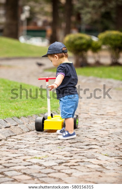 baby with a toy car in a\
park