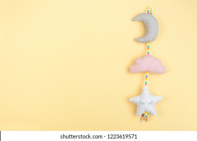 Baby toy on yellow background with blank space for text; top view, flat lay