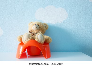 Baby toy sitting on the potty. Child training concept