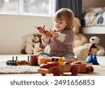 Baby, toys and play in home for development or learning, child in bedroom for motor skills. Young kid, house and relax game with wood cars for education or creativity, wellness or cognitive growth