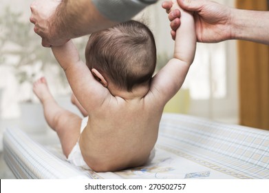 Baby Tries To Sit Down With The Help Of A Parent Charge