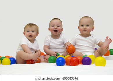 Baby Triplets Laughing And Playing With Colorful Balls