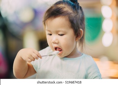 A Baby Try To Use Spoon For Feeding Her Self.