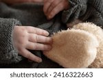 Baby trying to hold a stuffed animal 