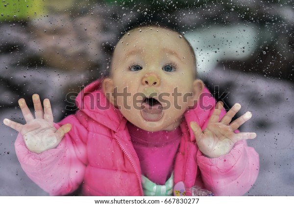 なめようとした赤ちゃんは窓ガラスの外に雨滴を落とし 顔をガラスに押し付ける の写真素材 今すぐ編集