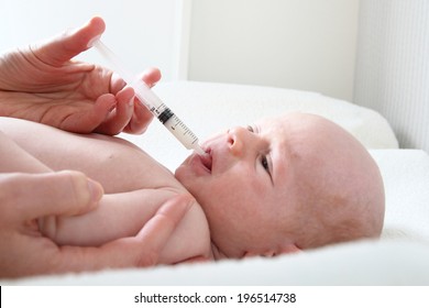 A Baby with vitamin D or vitamin K syringe