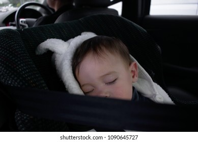 Baby In White Pluffy Jackget Sit Sleeping In Rear-facing  Car Seat 